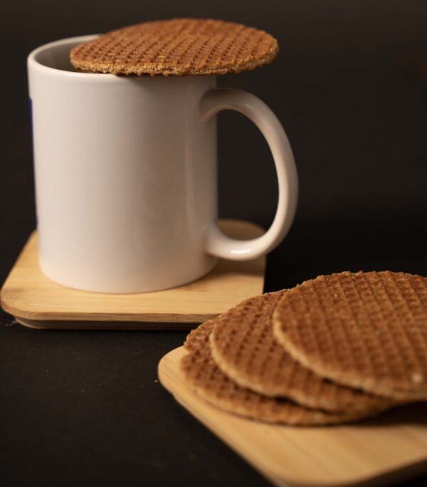 a white mug with a stroopwafel on top